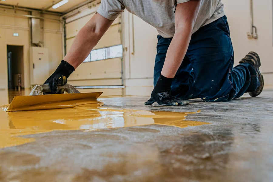 worker-coating-floor-with-selfleveling-epoxy-resin-industrial-workshop_558893-39